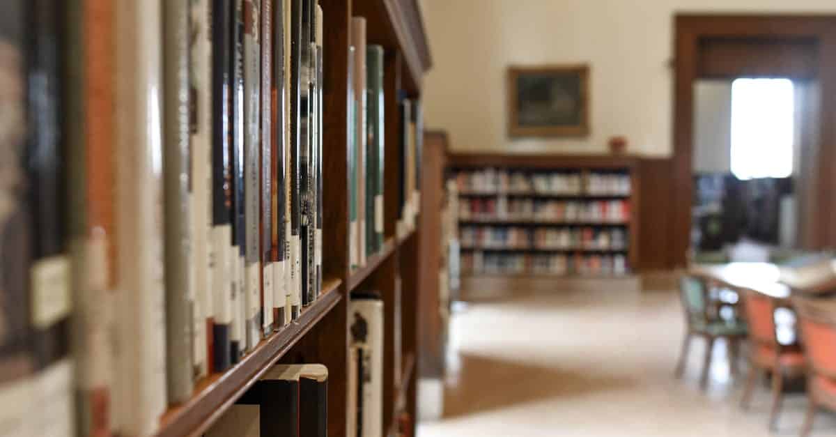 A quiet library interior featuring bookshelves, seating, and a study area for learning and reading.