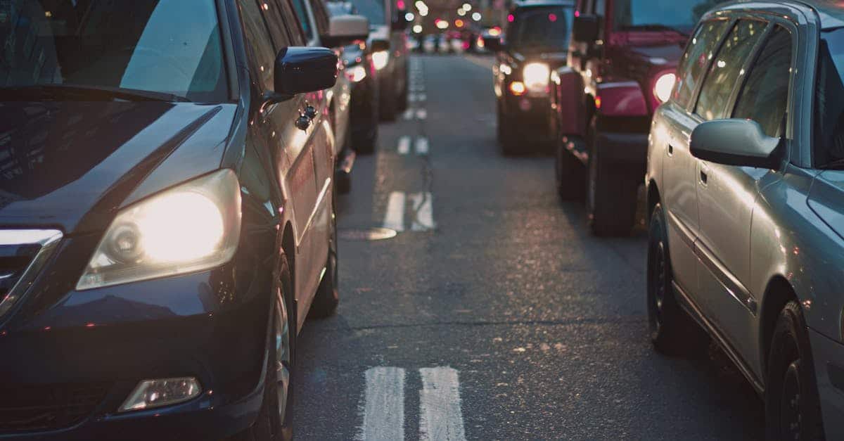 A congested city street lined with cars stuck in traffic at dusk, showcasing urban life.
